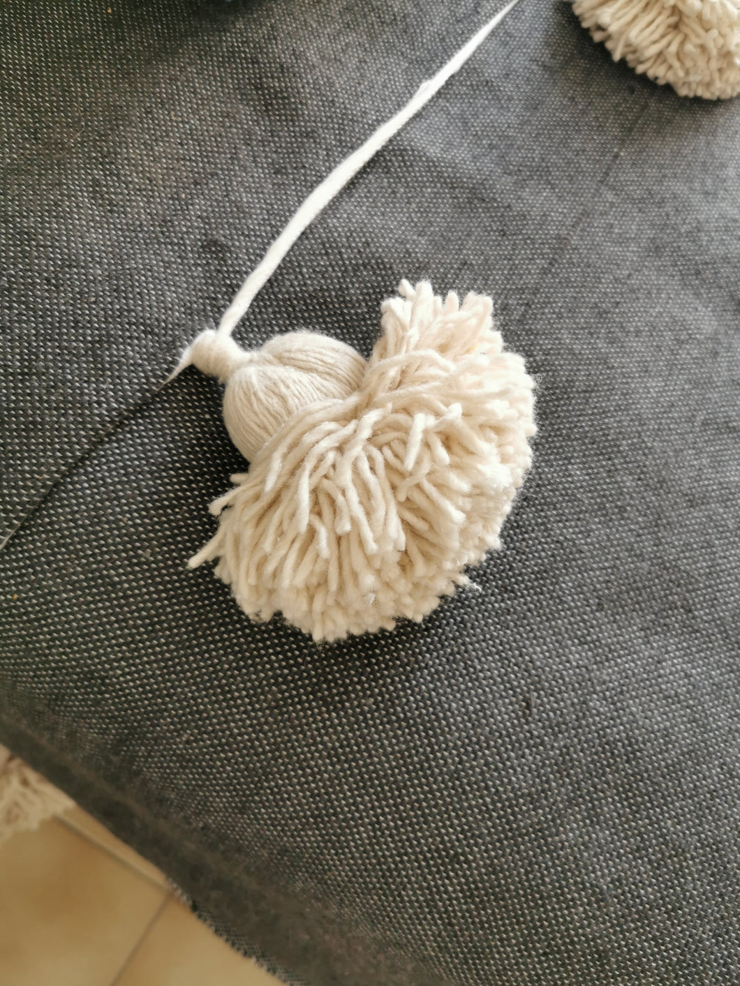 Plaid gris antracite pompons beige